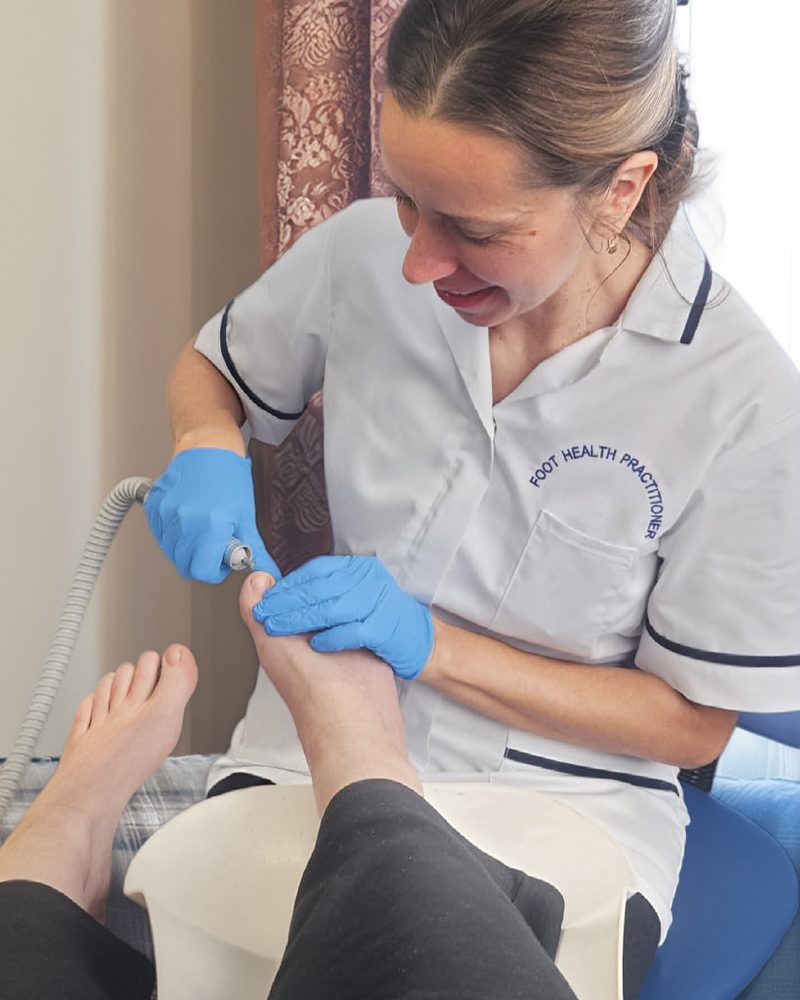 Lina caring for a client's feet during a home visit